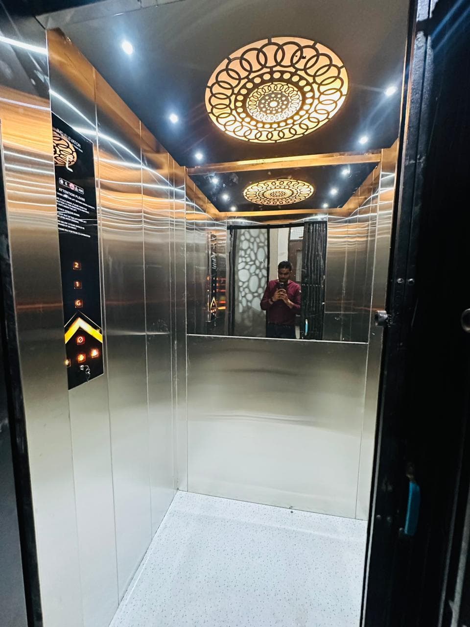 Luxury gold-finish elevator cabin with decorative circular ceiling