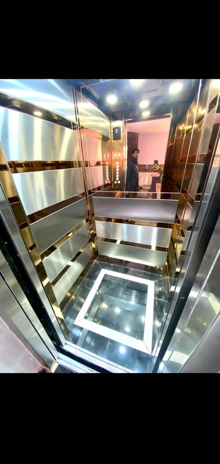Premium gold-finish elevator cabin with glass floor detail